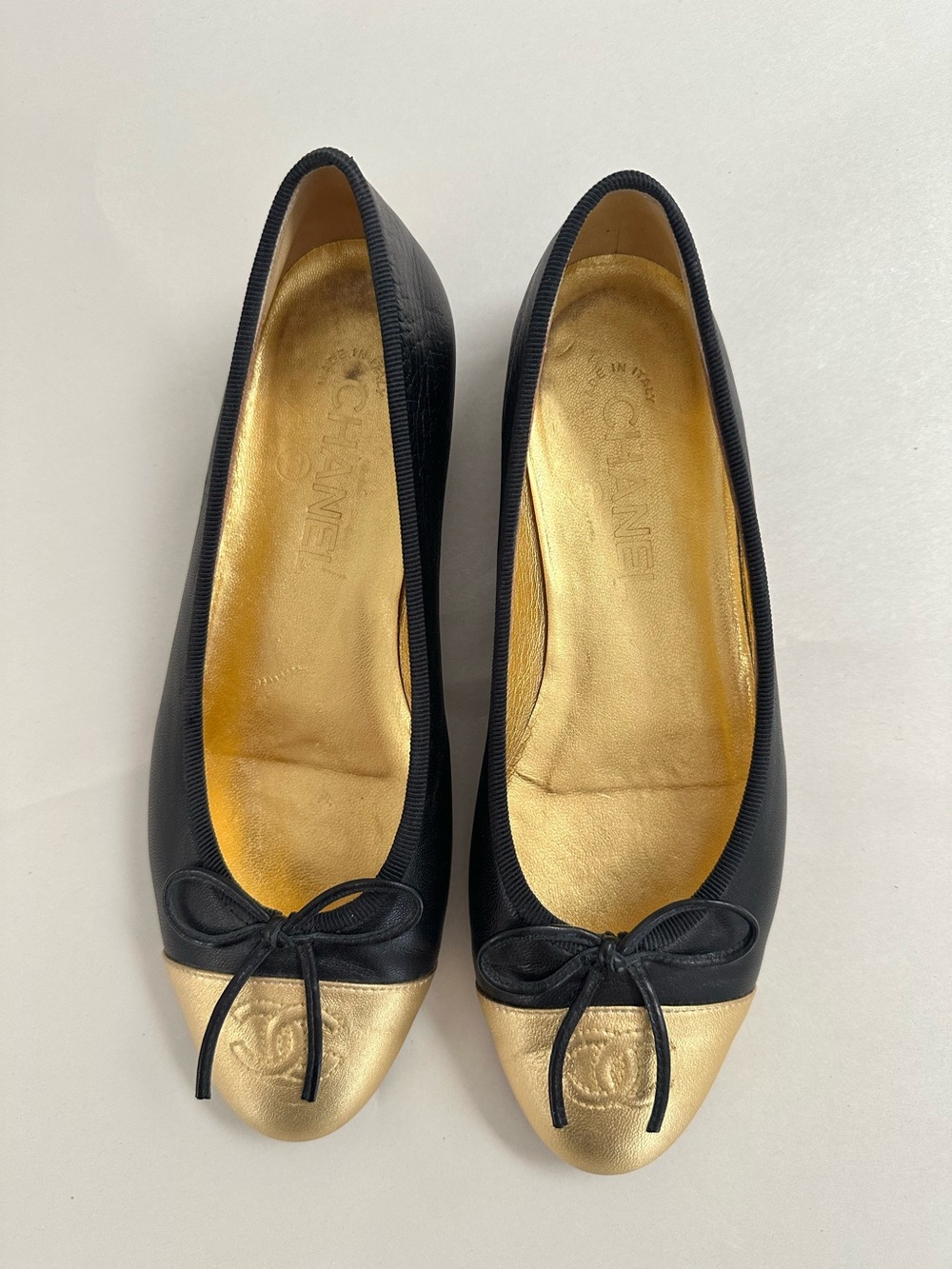 CHANEL Black and Gold Cap-Toe Bow Ballet Flats